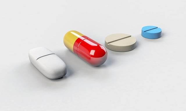 An image of a row of tablets and a capsule on a table.