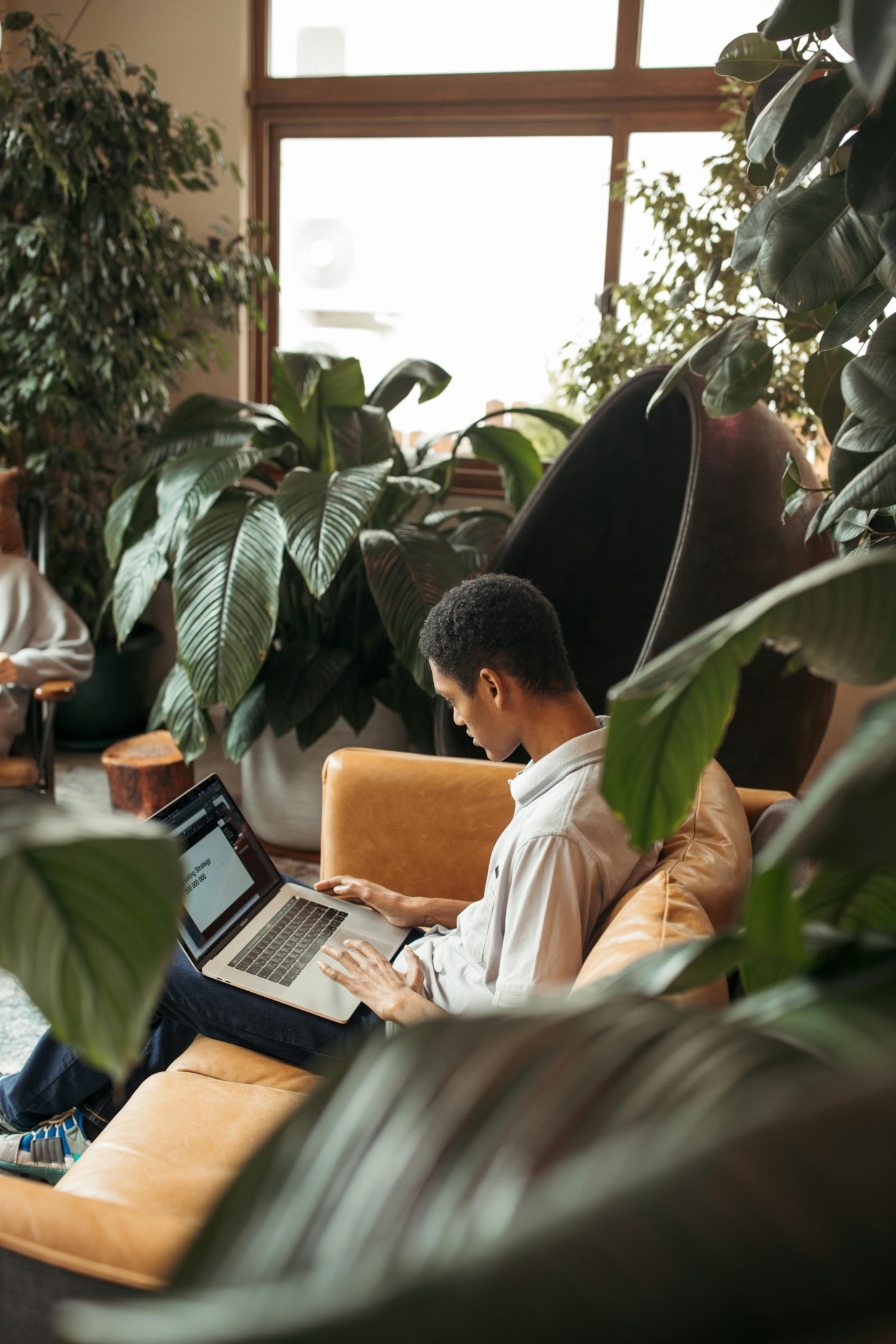 A man working on his laptop and concentrating as if working on a project for a remote client.