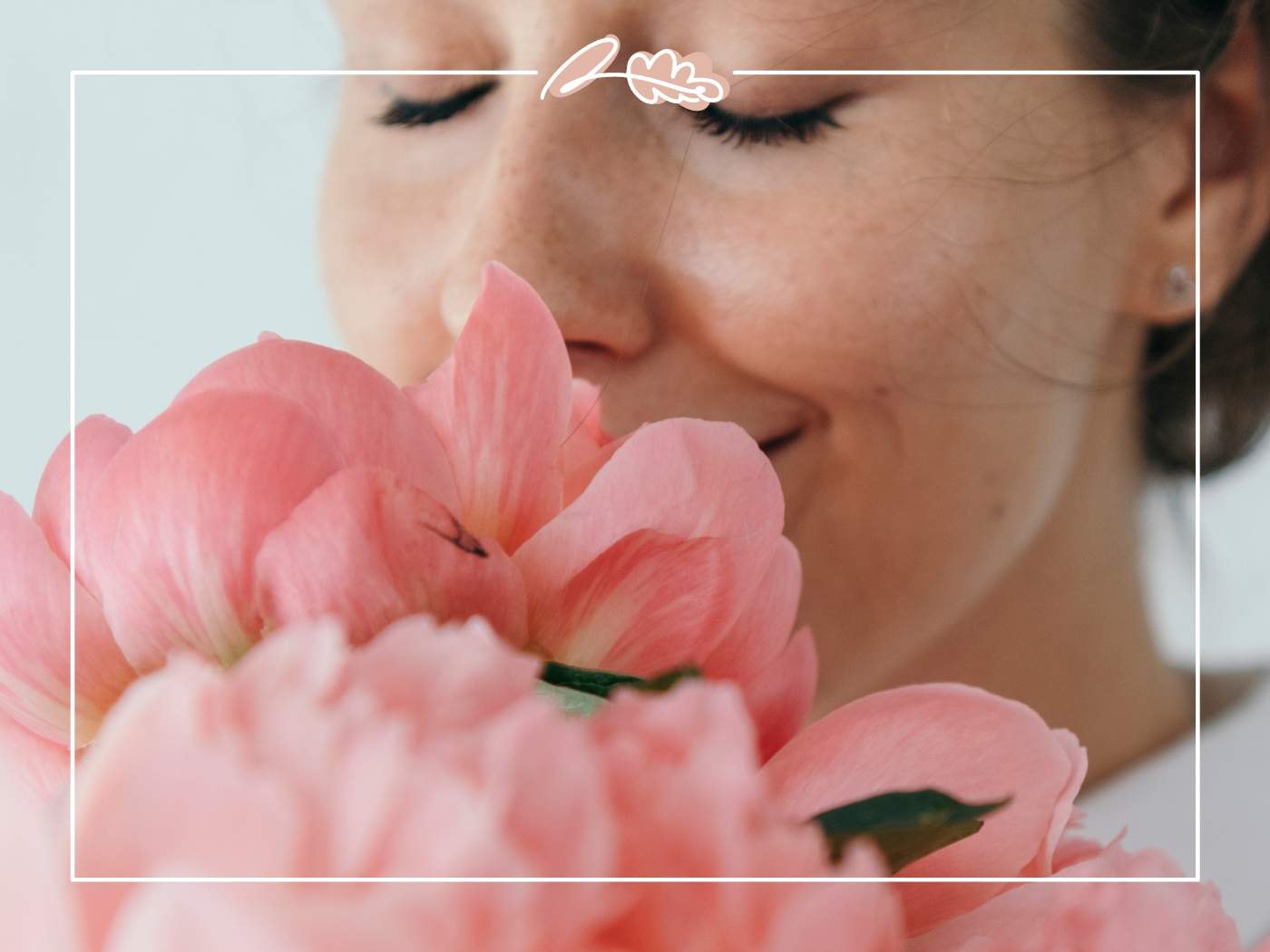 A woman smiling while holding a bouquet of pink peonies, featured in '11 Fabulous Reasons to Buy Peonies'