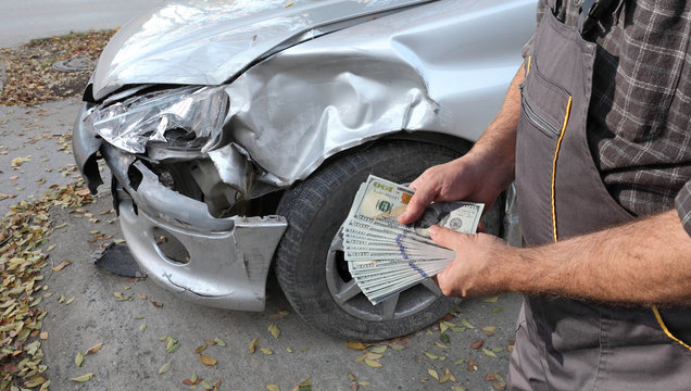 A junk car with a cash offer in the background