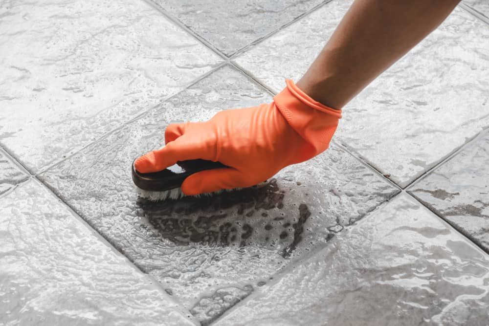 Scrub and clean the shower floor with vinegar solution