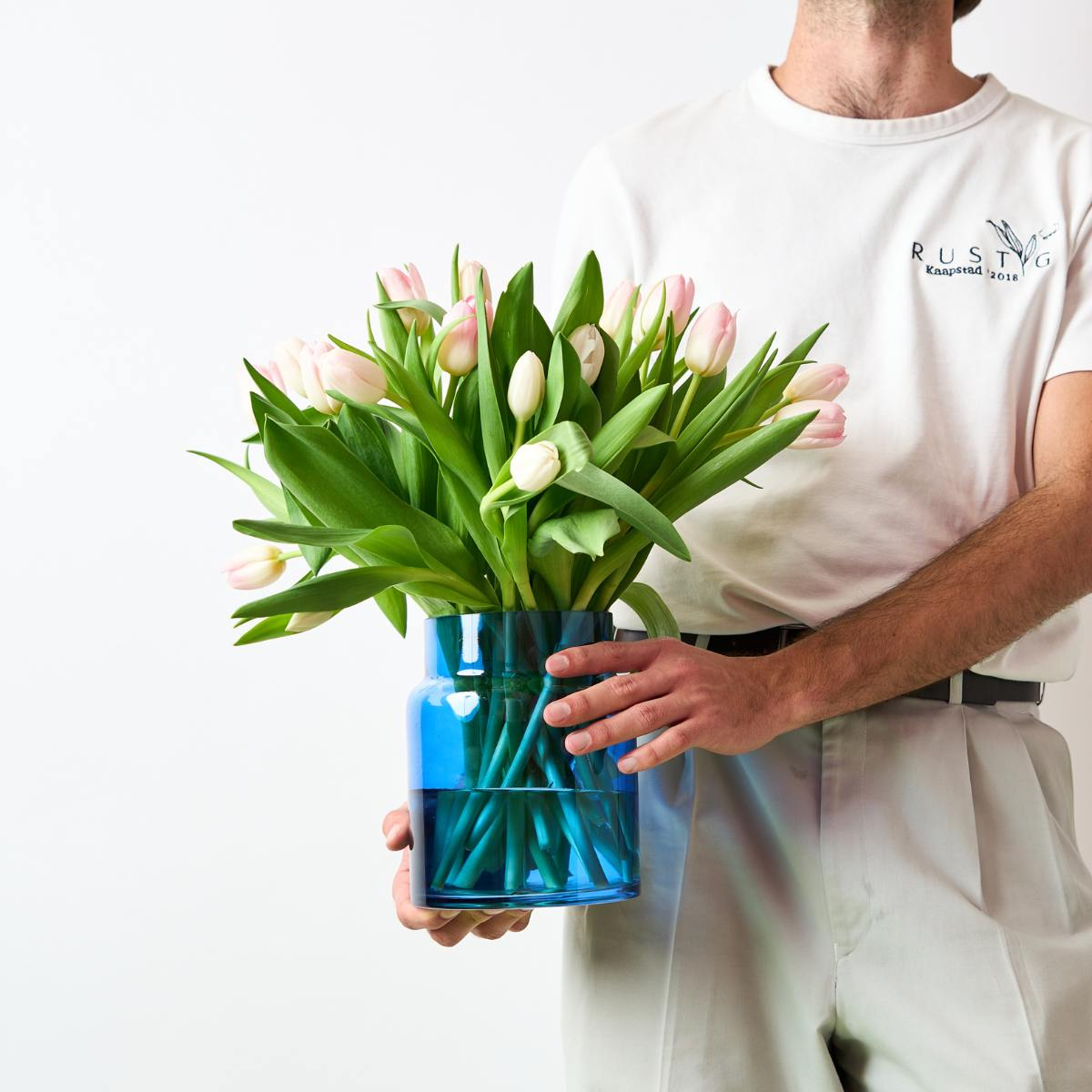 tulips in a blue vase, flower delivery cape town, mother's day, man holding flowers
