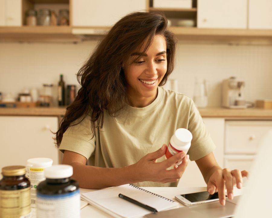Women holding up digestive enzymes bottle in her hand, smiling