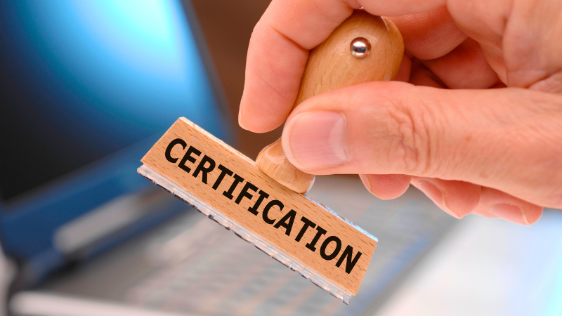 A close up image of a person holding a certification stamp