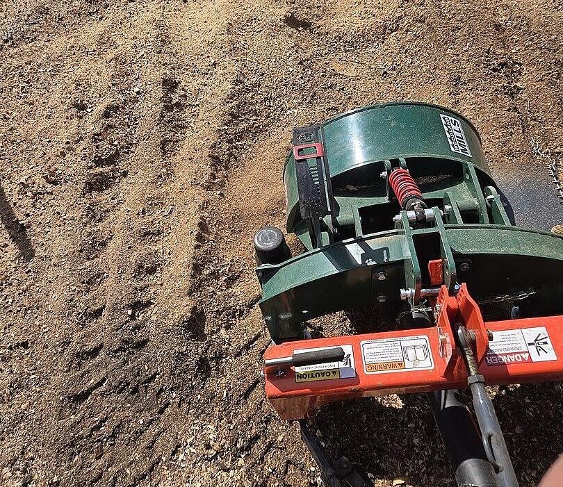 A Woodland Mills PTO stump grinder over a clean area of land.