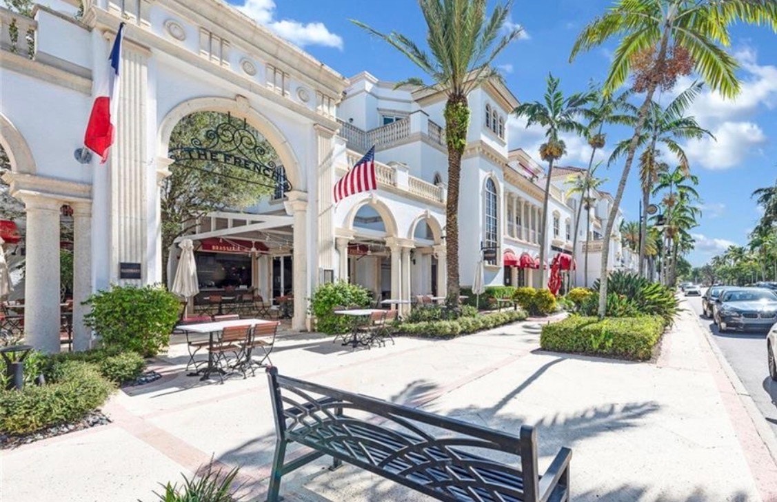 The image depicts a picturesque tree-lined street in Lake Park, showcasing a mature oak canopy that adds charm to the desirable neighborhood. This serene setting exemplifies relaxed Florida living, with well-maintained homes nestled under the lush greenery.
