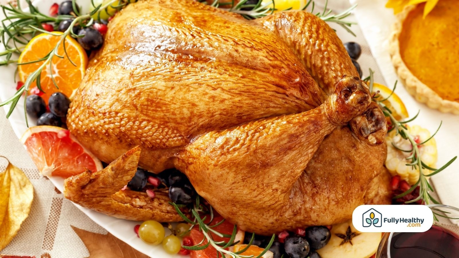 Whole roasted Thanksgiving turkey surrounded by fruit and herbs