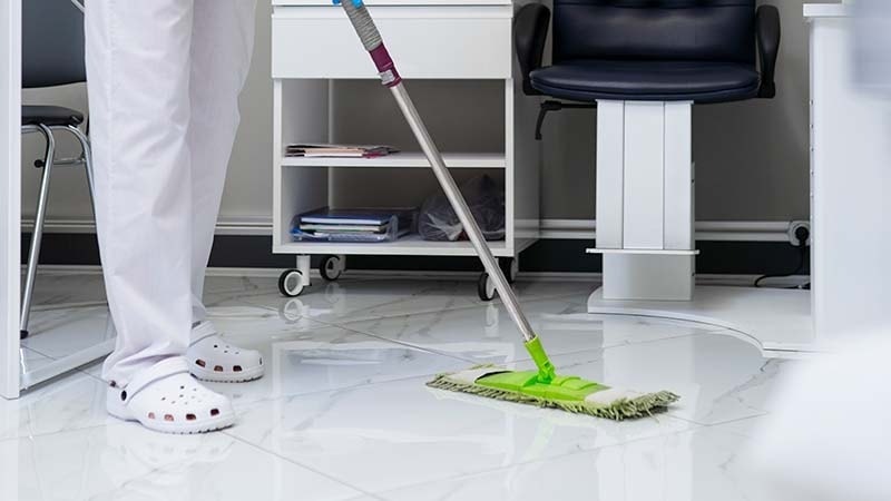 A green mop on a white marble floor