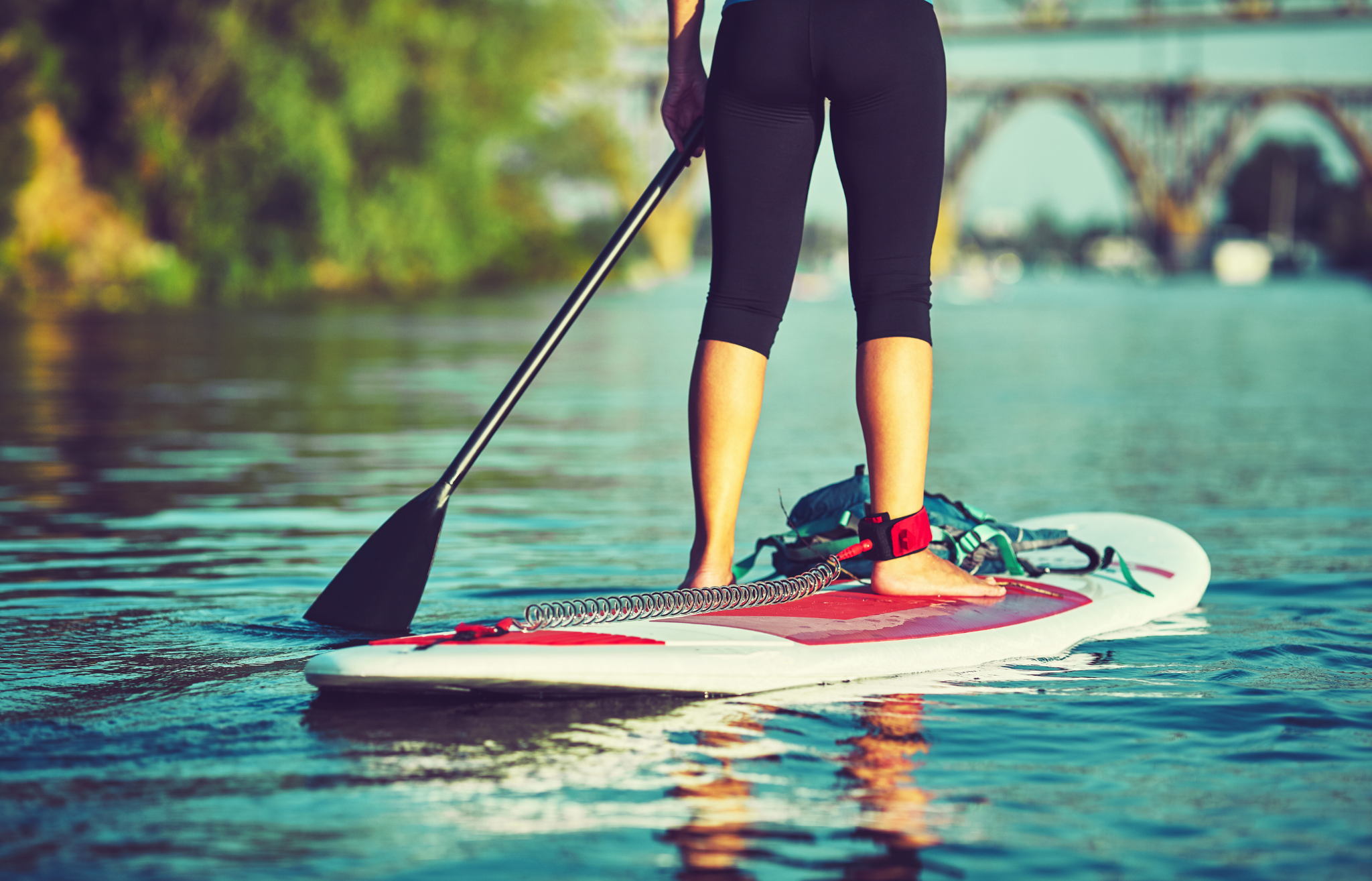 Close up of paddle board with leash attached to ankle - Adventure Wise Travel Gear