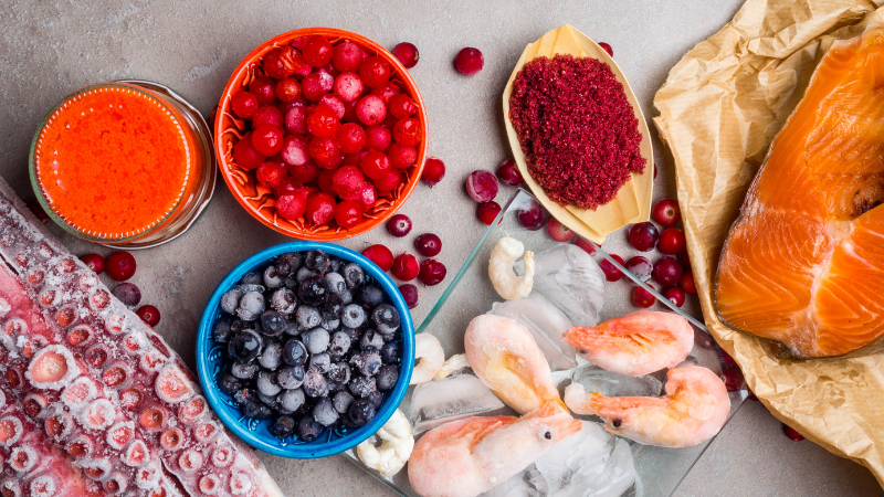 Ein Bild von natürlichen Quellen von Astaxanthin, wie Lachs, Beeren und Mikroalgen.