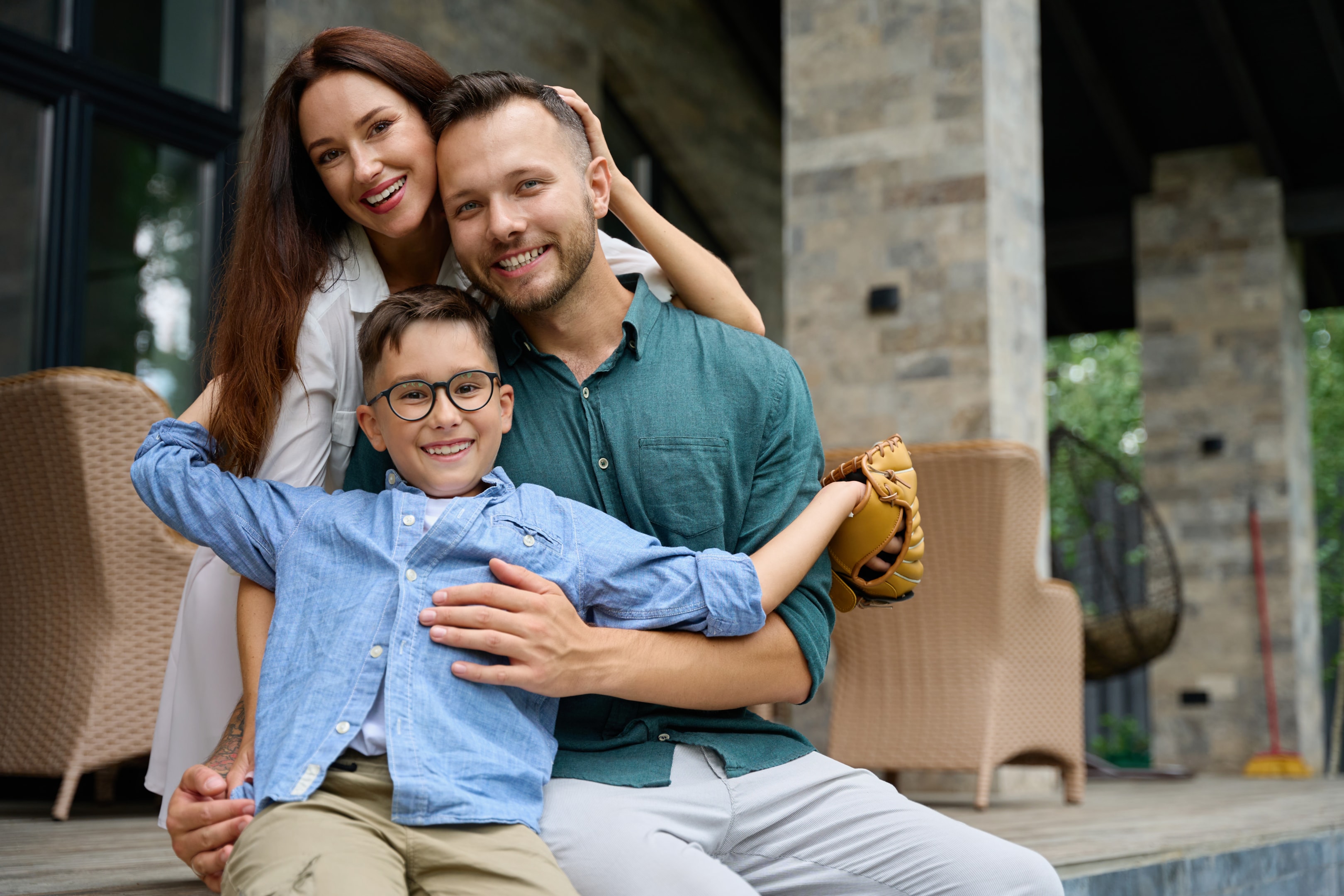 Happy family, hugging, settled down on terrace of country house