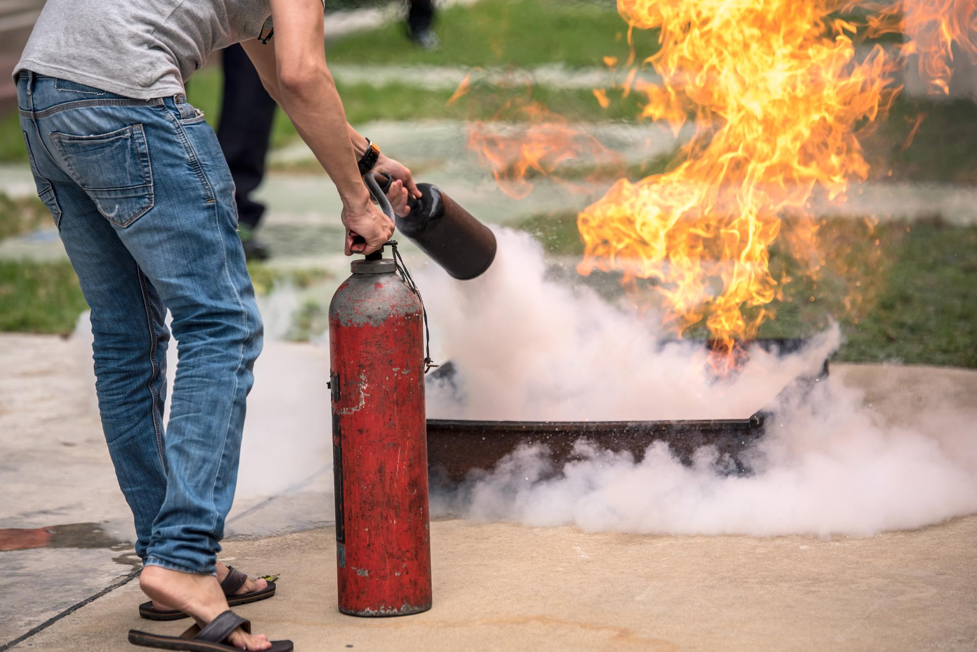 A man using fire extinguisher to put out fire