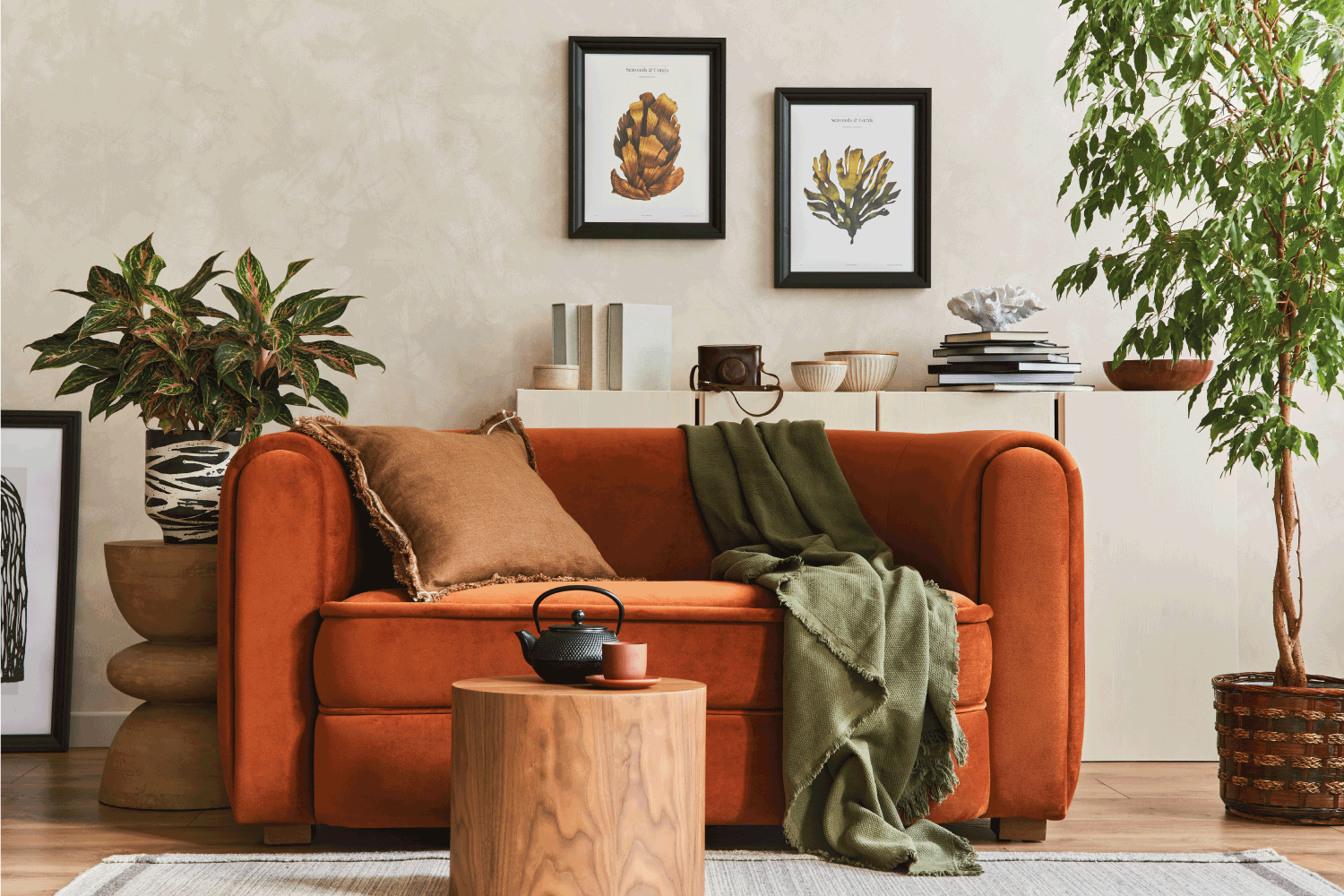 Sofa terakota gelap yang kontras dengan warna dasar dinding beige muda, via homedecorbliss