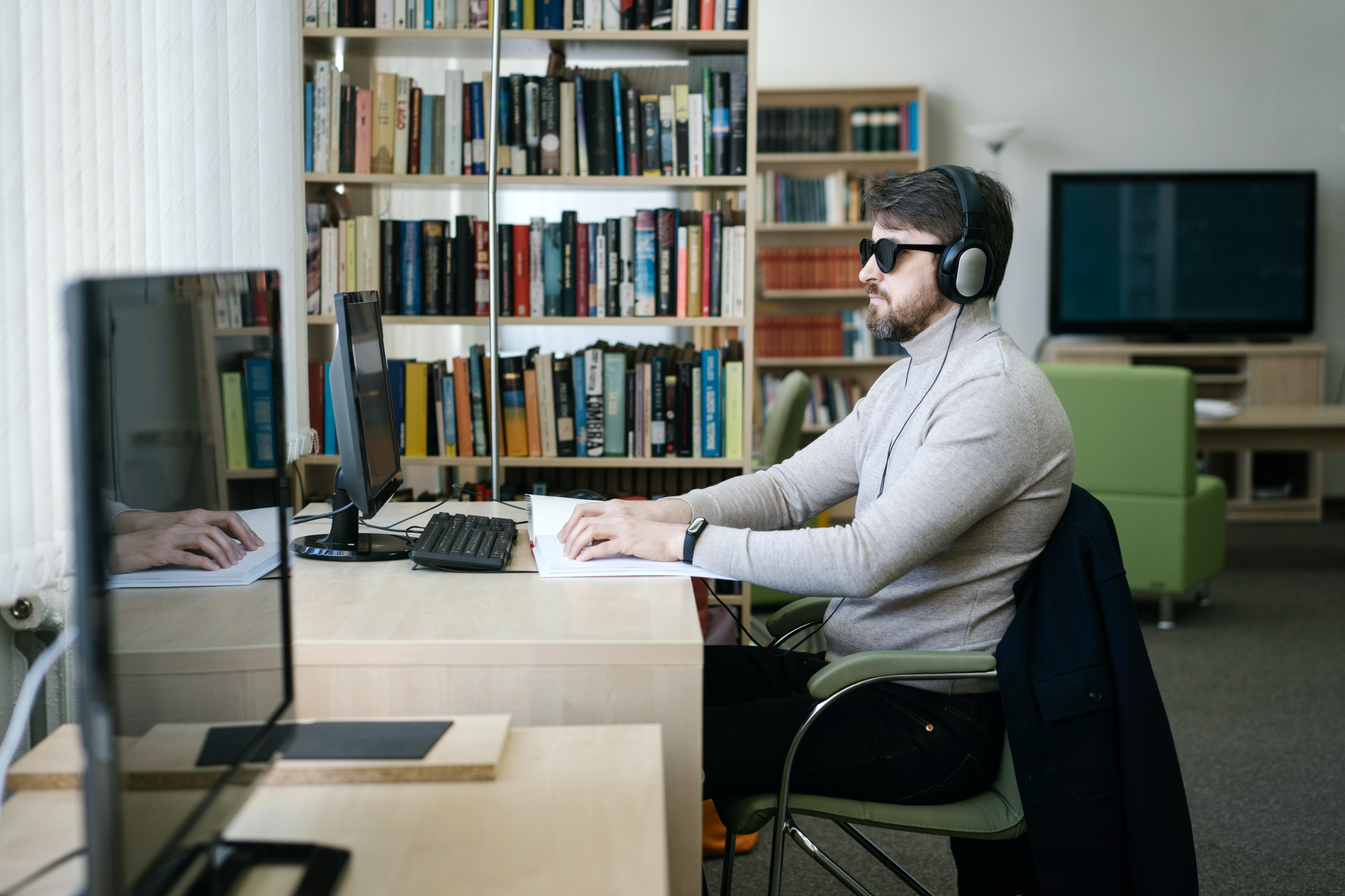 A disabled person using assistive techinolgy while using a computer.