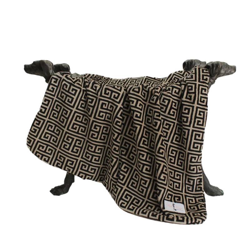 A black and tan blanket with a Greek key pattern is displayed on dog-shaped supports, showcasing How to Keep Dog Blankets Clean