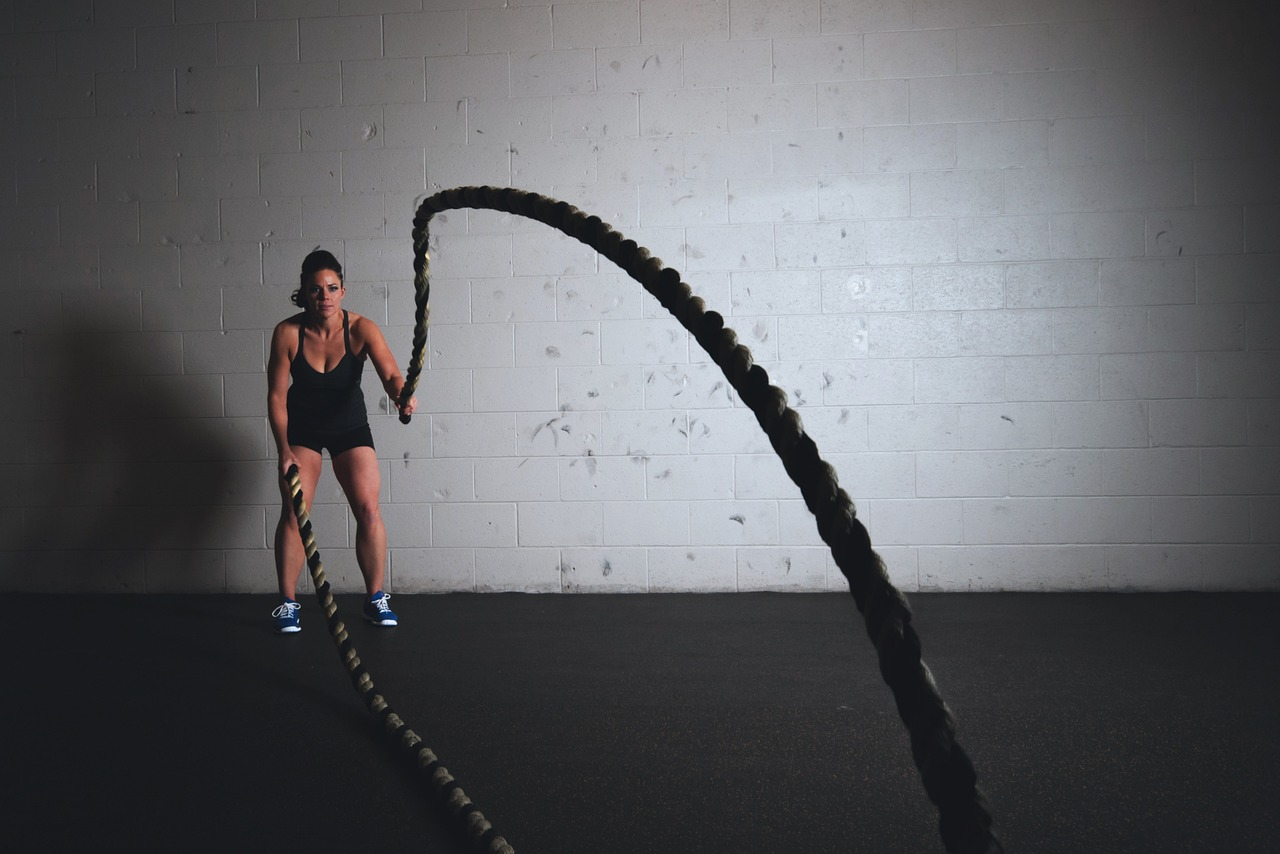 A woman using a black polyester rope as an exercise rope