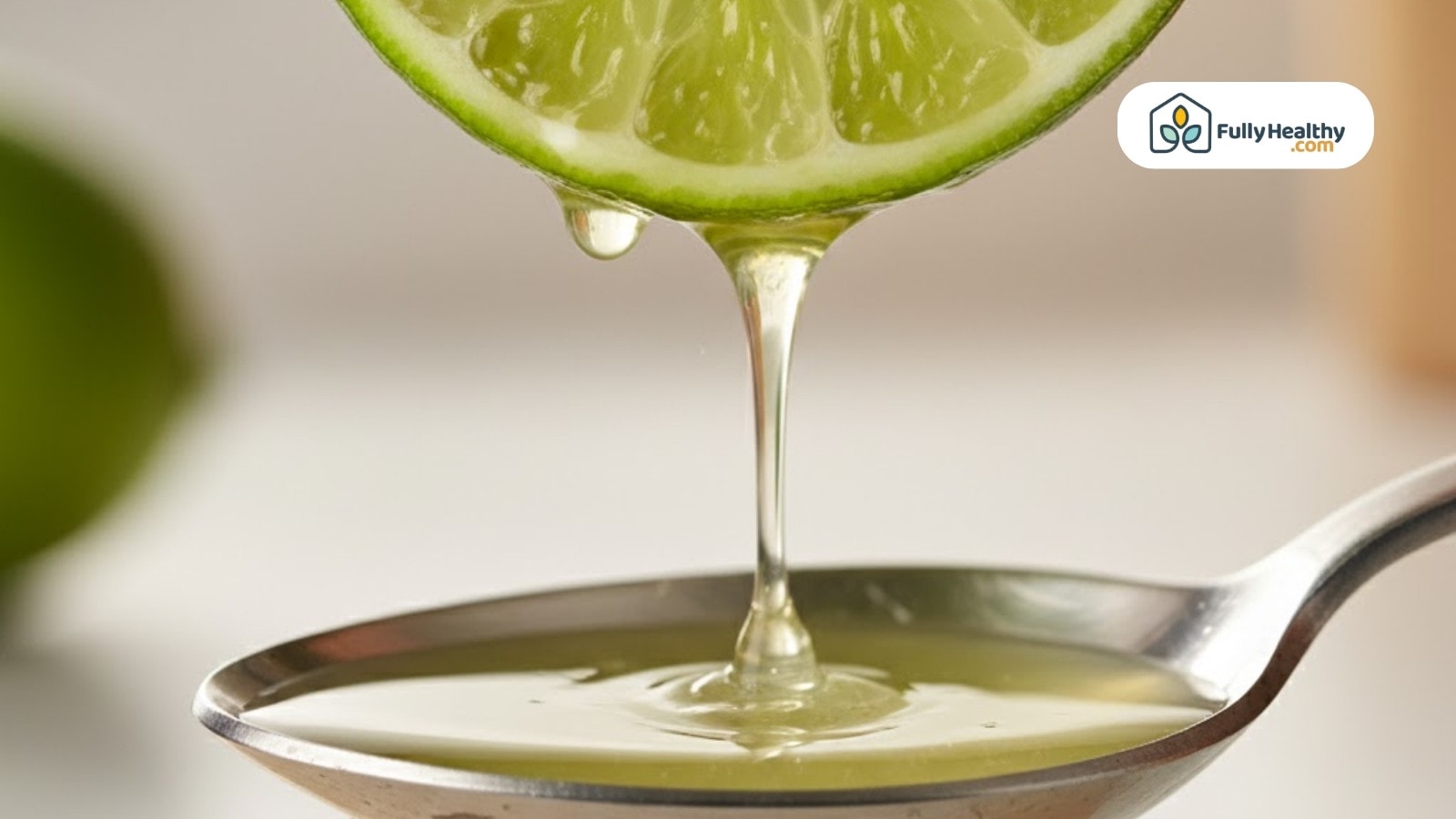 Lime juice dripping from sliced lime into metal spoon close-up view