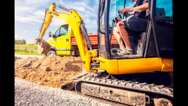 A backhoe loading soil on a truck. 