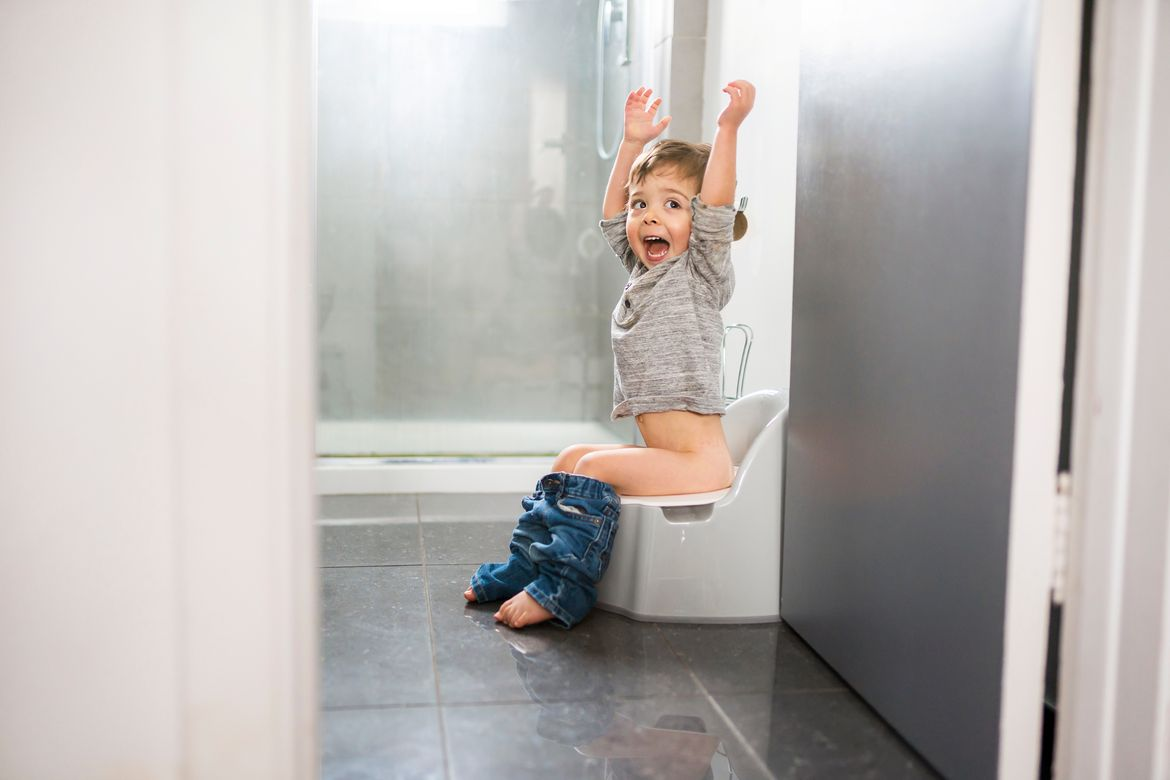 Toddler sitting on potty in bathroom