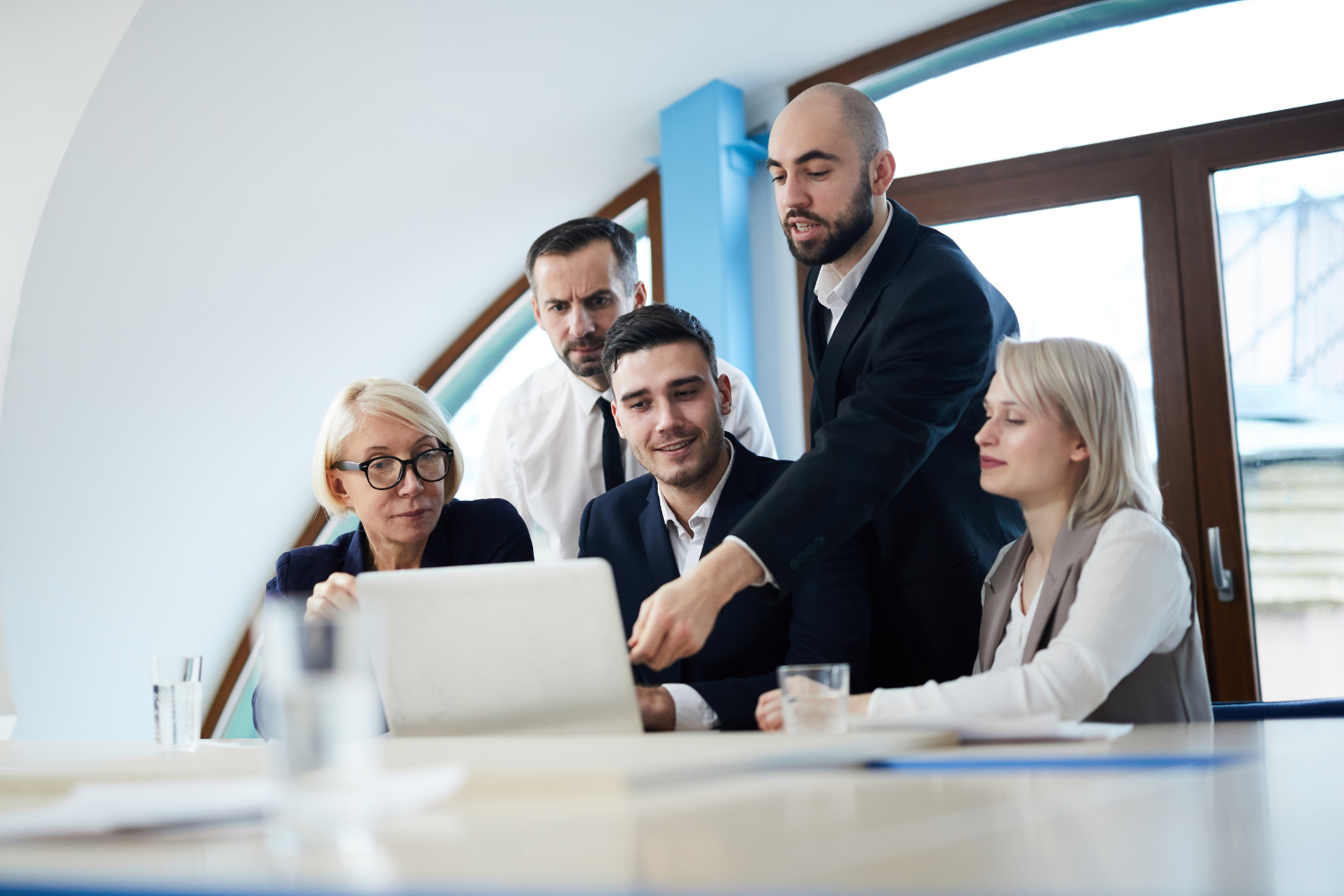 A group of professionals looking at laptop.