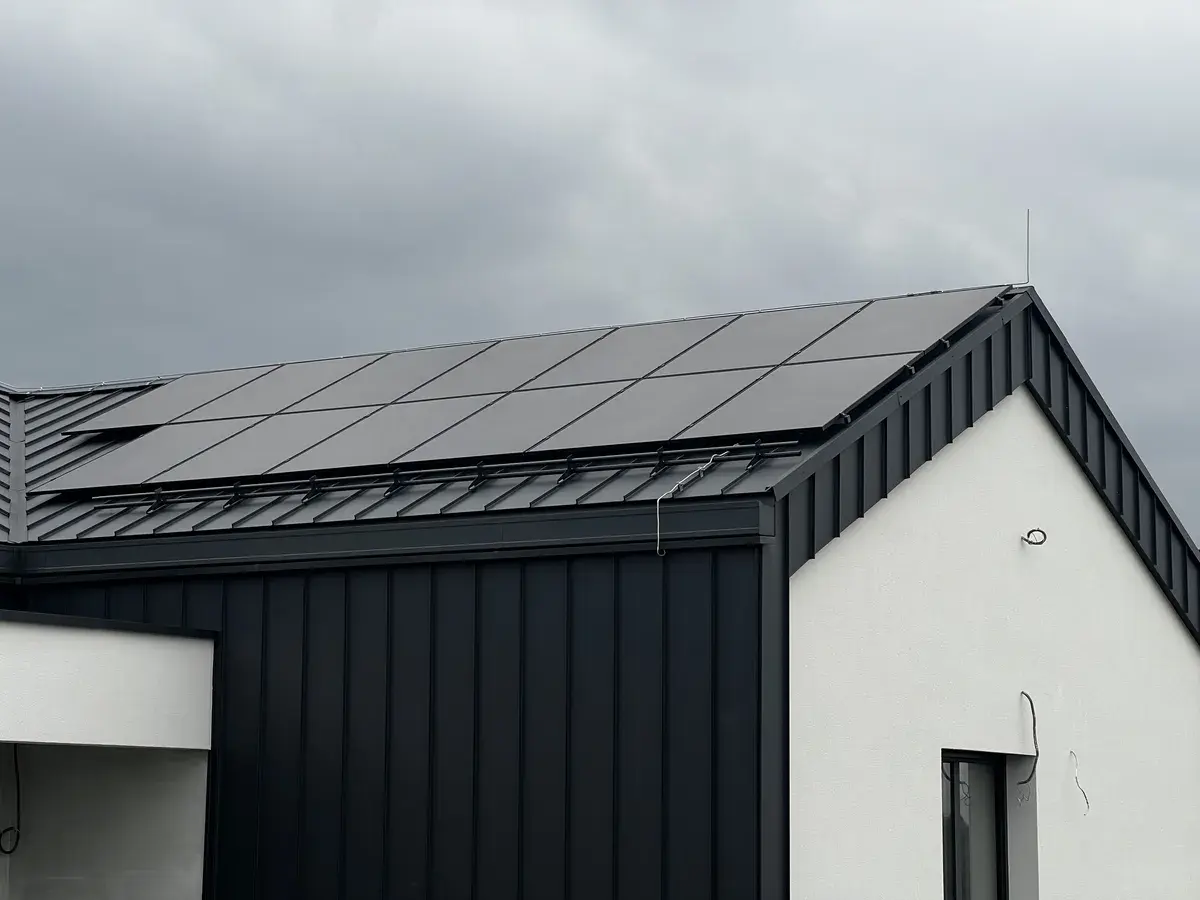 Na dachu domu jednorodzinnego znajdują się panele fotowoltaiczne, które efektywnie wykorzystują energię słoneczną do produkcji energii elektrycznej, przyczyniając się do całkowitej niezależności energetycznej budynku. Dzięki nowoczesnym technologiom, mieszkańcy mogą cieszyć się znacznymi oszczędnościami finansowymi oraz niezawodnym zasilaniem. Odporność wodę, produkty, fotowoltaika