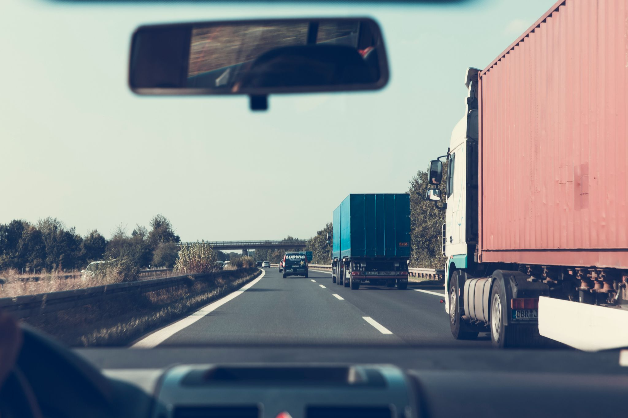 View of two trucks in the right lane from a car driver's perspective