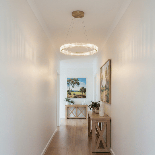 Ribbed glass ring pendant lighting spreading light across a narrow white hallway.