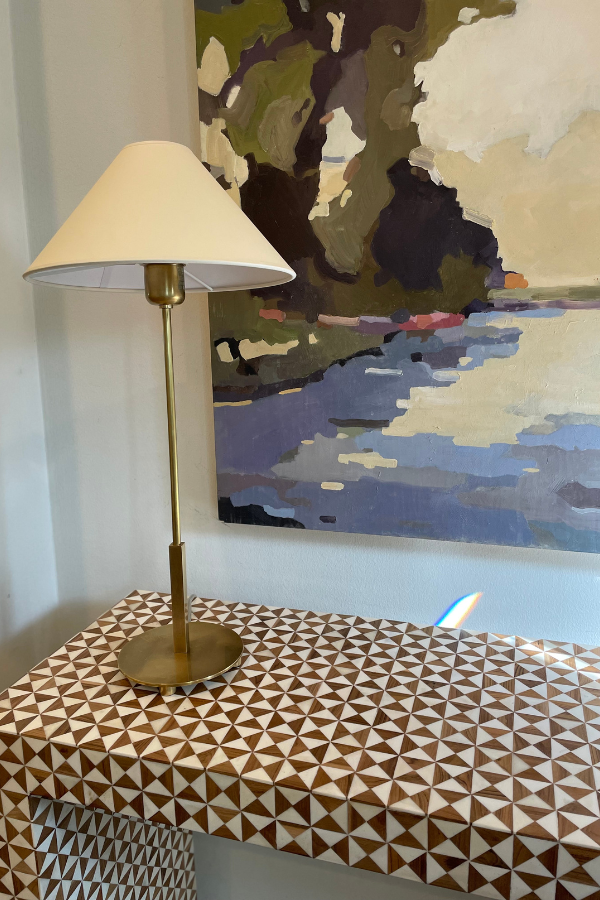 paintings above a table with lamp