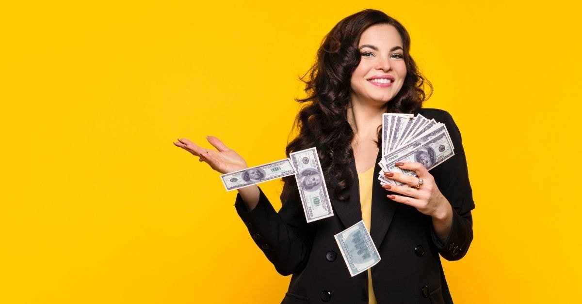 A financially responsible woman smiling and holding cash, symbolizing financial success and management.