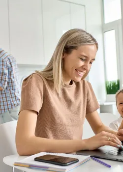 image of smiling mom working at computer
