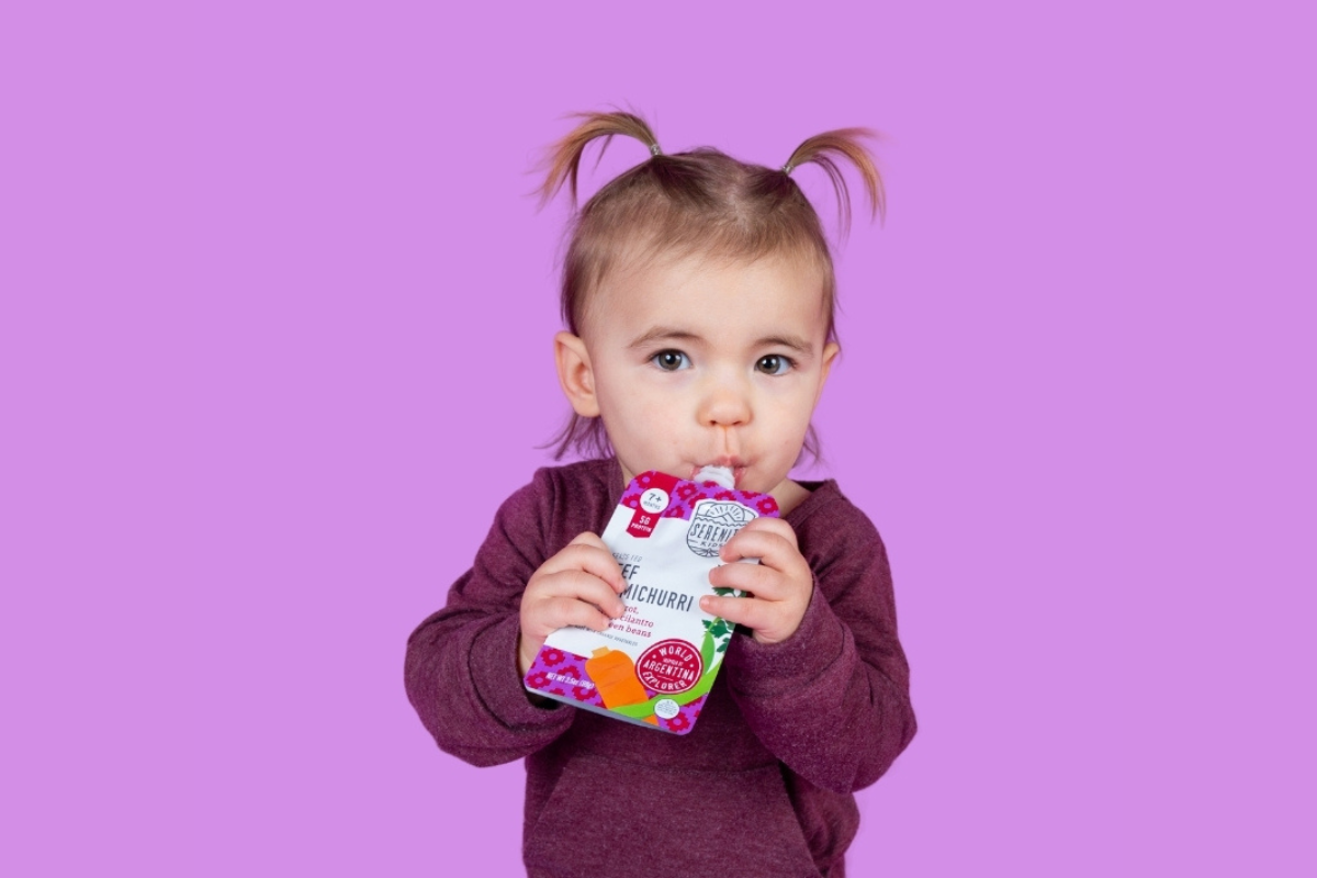 A little girl eating meat