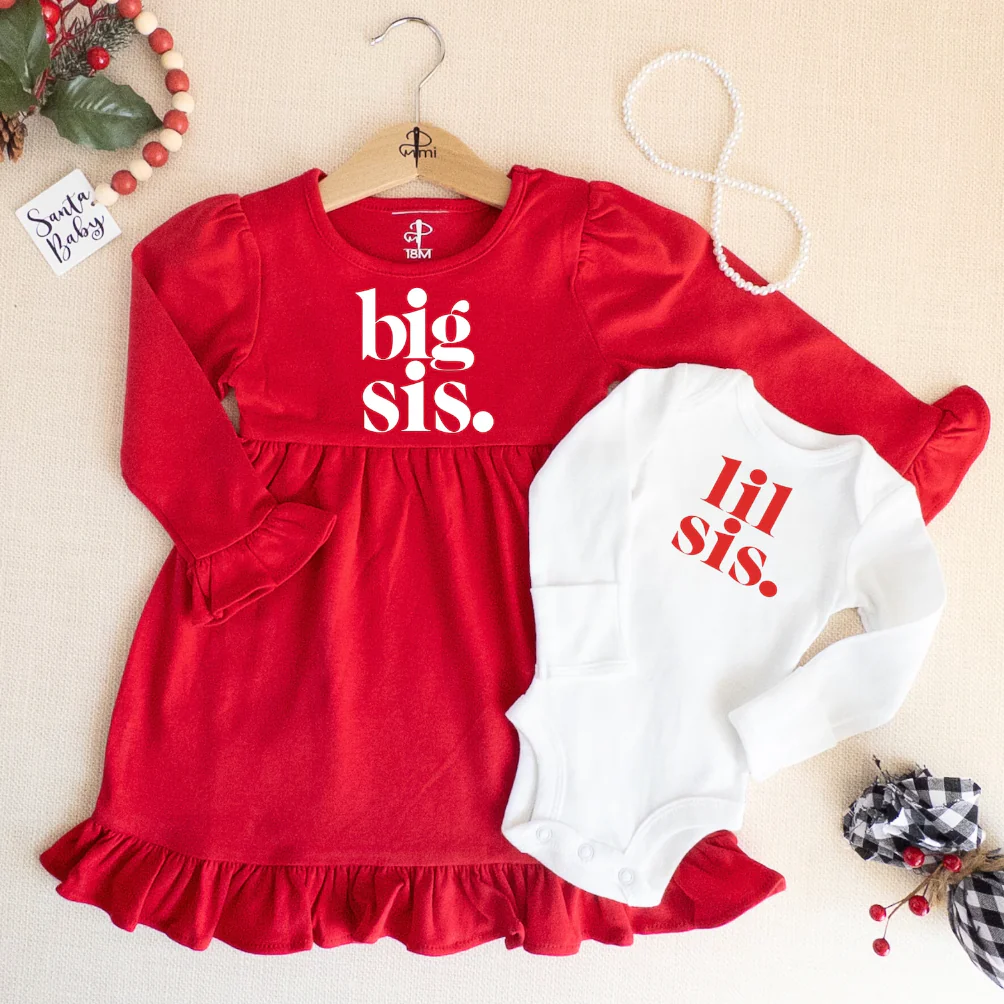 Red dress with white print that reads, "big sis." and white bodysuit with red print that reads "lil sis."
