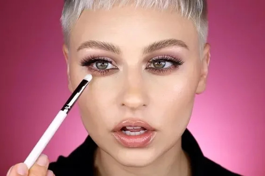 Model applying eyeshadow on the lower lash line