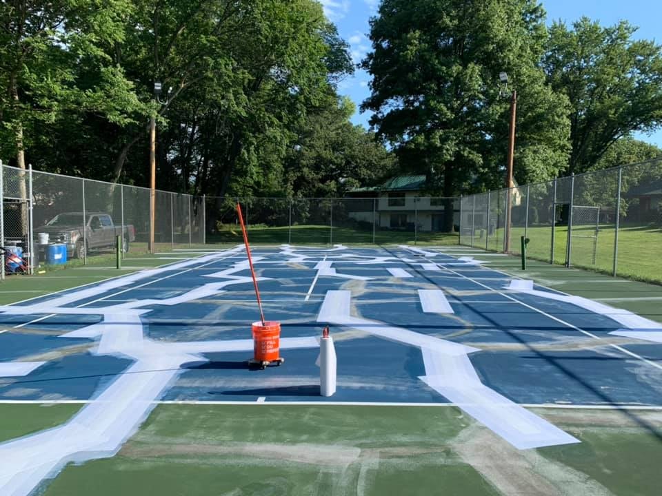 Pro Track & Tennis resurfacing a pickleball court to smooth the surface and prepare it for striping.