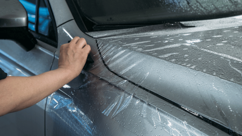 A man is applying the ppf on the car.