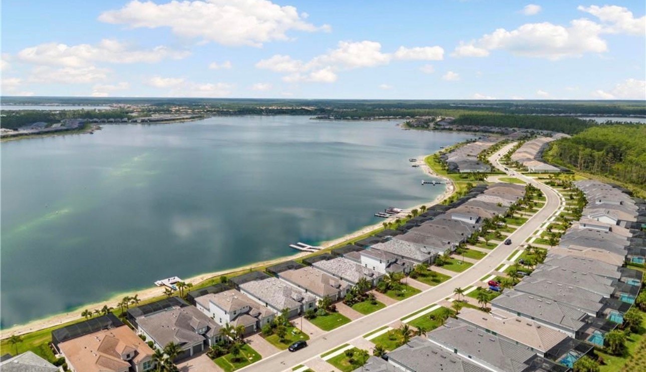 The image depicts a luxurious lakefront home featuring an expansive covered lanai and a private boat dock, perfect for enjoying the serene lake views and embracing the lakefront lifestyle. Located in a master-planned community in Southwest Florida, this property offers convenient access to world-class amenities, including resort-style swimming pools and walking trails for active residents.