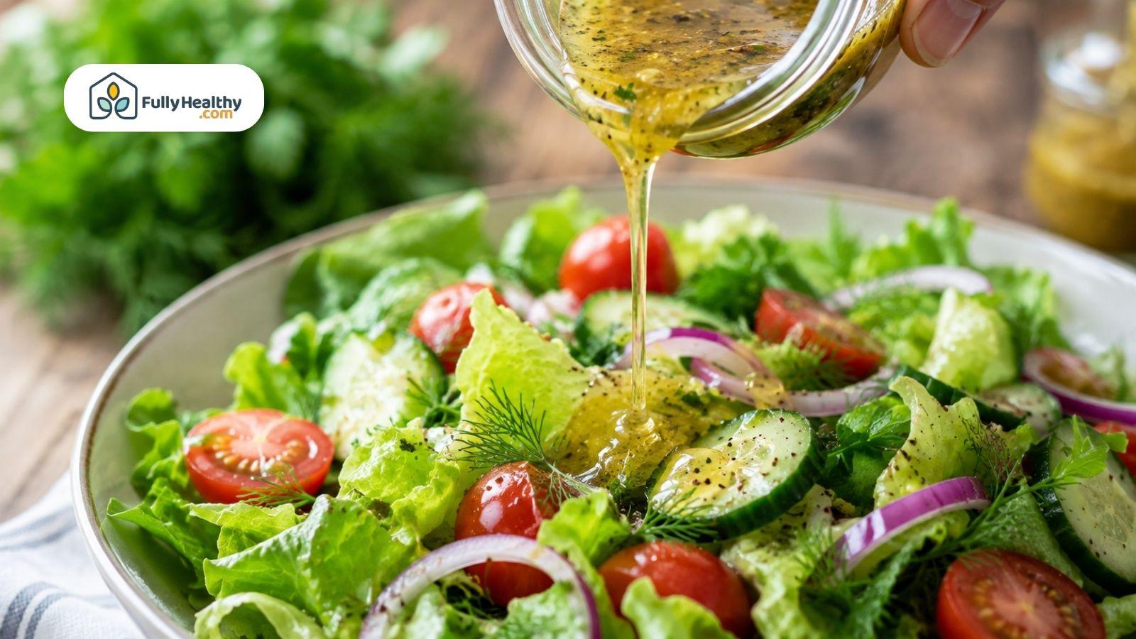 Homemade vinaigrette poured over fresh salad with tomatoes and cucumber.