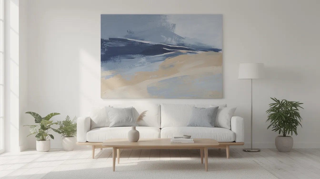 En stor abstrakt tavla i blå och sandiga toner hänger på väggen i ett minimalistiskt skandinaviskt vardagsrum, vilket skapar en modern och stilren atmosfär. Konsten ger rummet liv med sina olika färger och former, vilket ofta är en perfekt del av inredningen i hemmet.