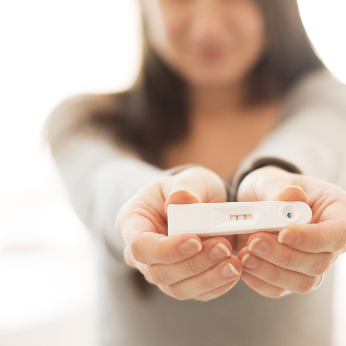 Woman holding pregnancy test up