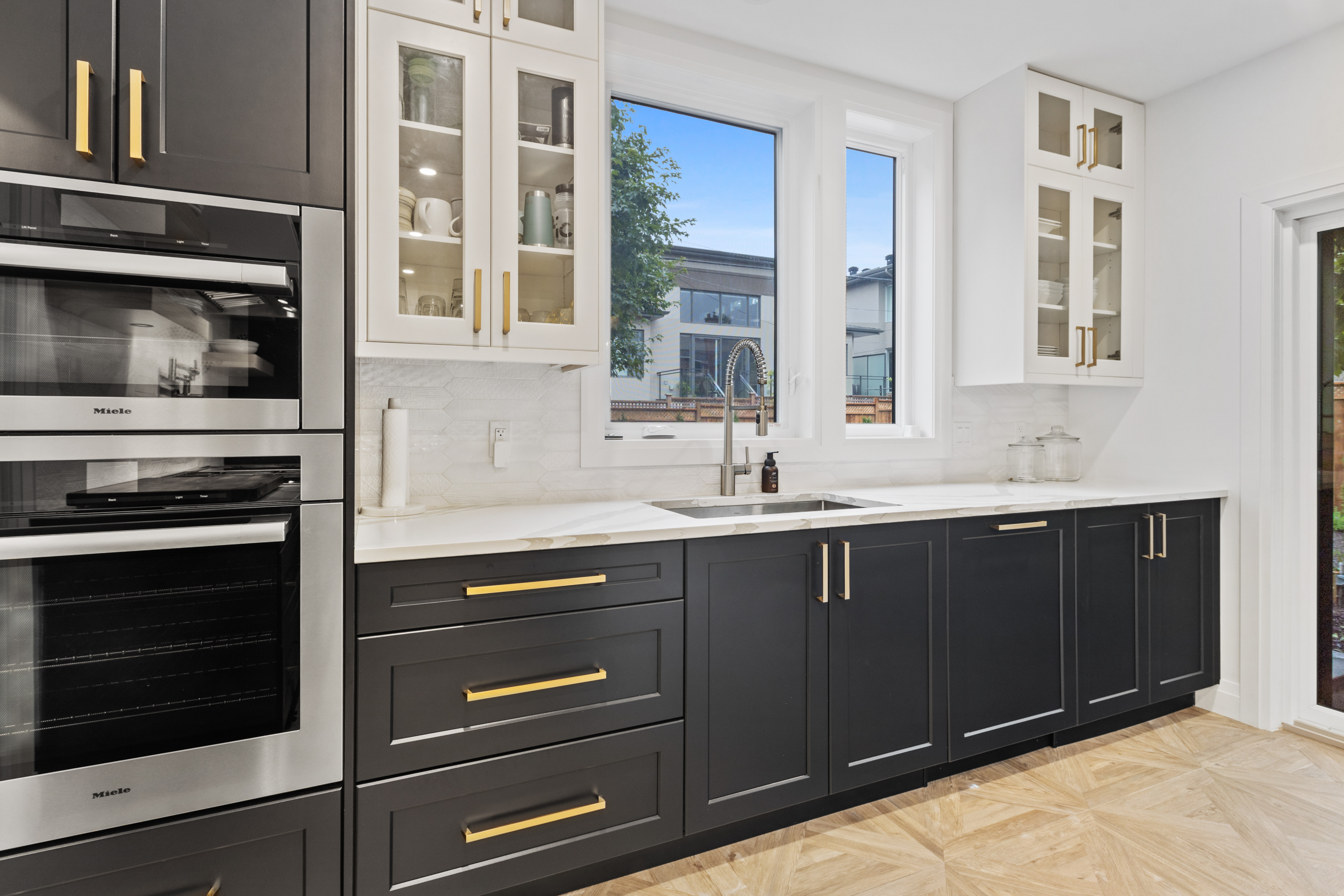 modern kitchen with white and black cabinets and gold hardware