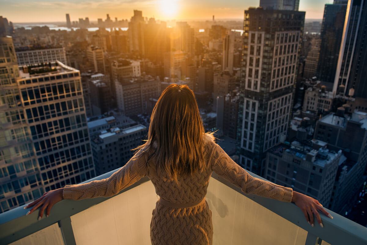 Woman stands on a balcony 