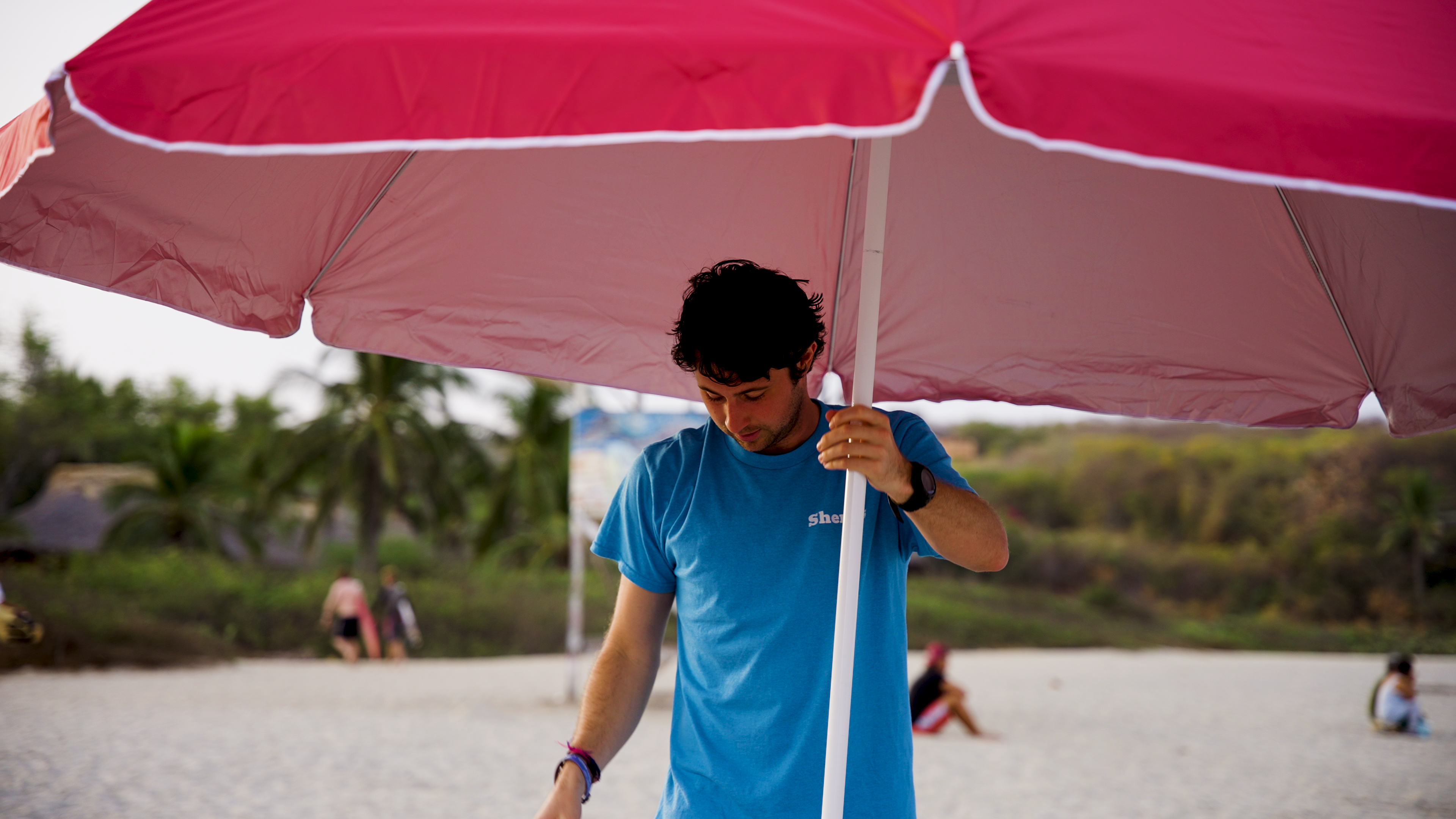 A Beach Sherpa with an umbrella on Wrightsville Beach, beach week, great spot for family, state holiday