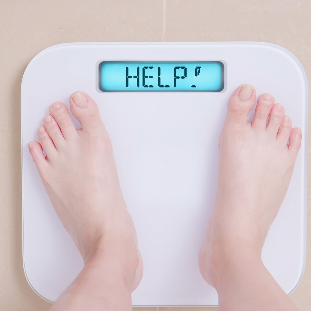 A person measuring their body weight with a scale