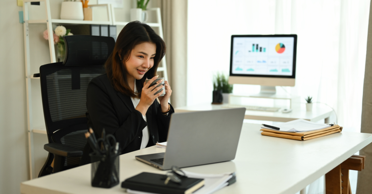 Woman reviewing payroll reports on her laptop while learning what is payroll management for her OnlyFans business.