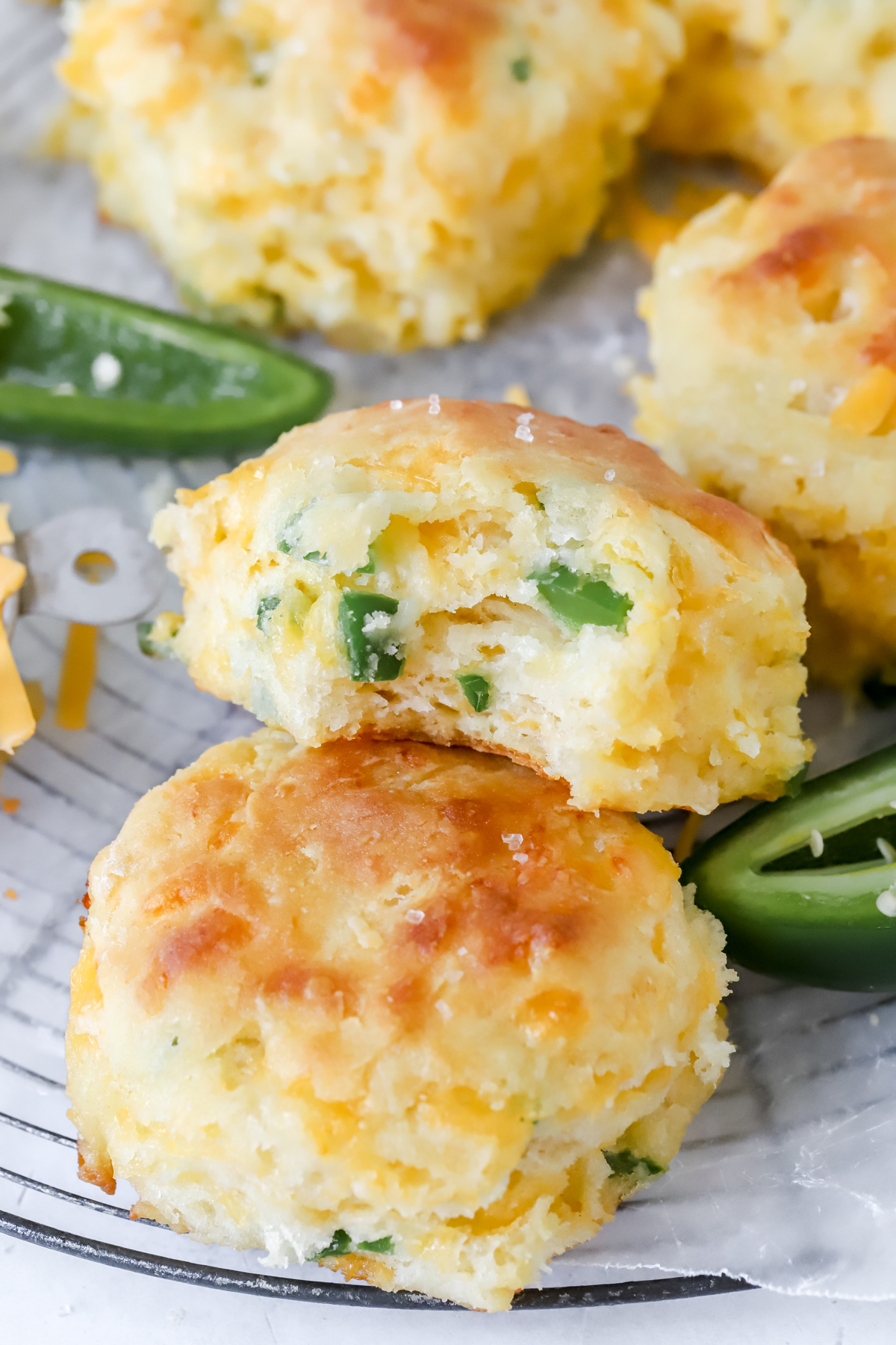 two cheddar jalapeno biscuits, one has a bite taken out of it