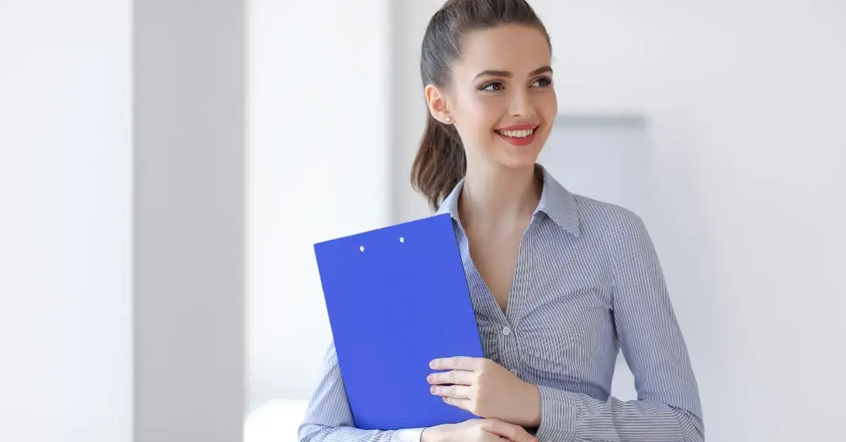  Professional woman holding a blue folder, showcasing the benefits of OnlyFans tax compliance services.