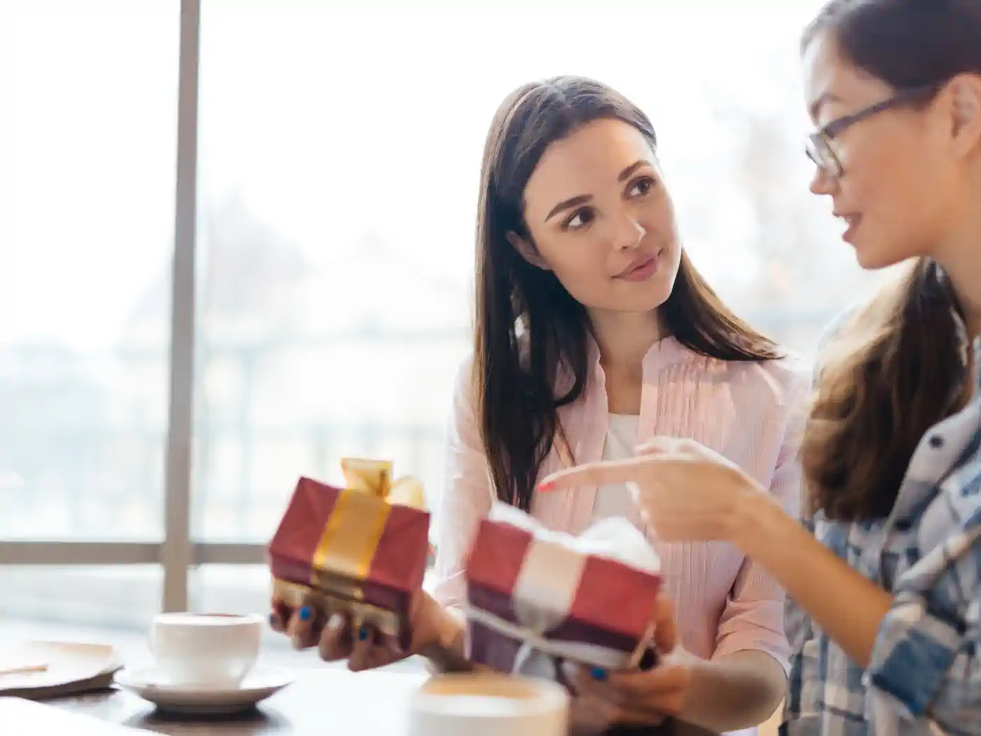 Two women discussing and holding luxury gift boxes with ribbons - Fabulous Flowers and Gifts, Luxury Gift Boxes collection.