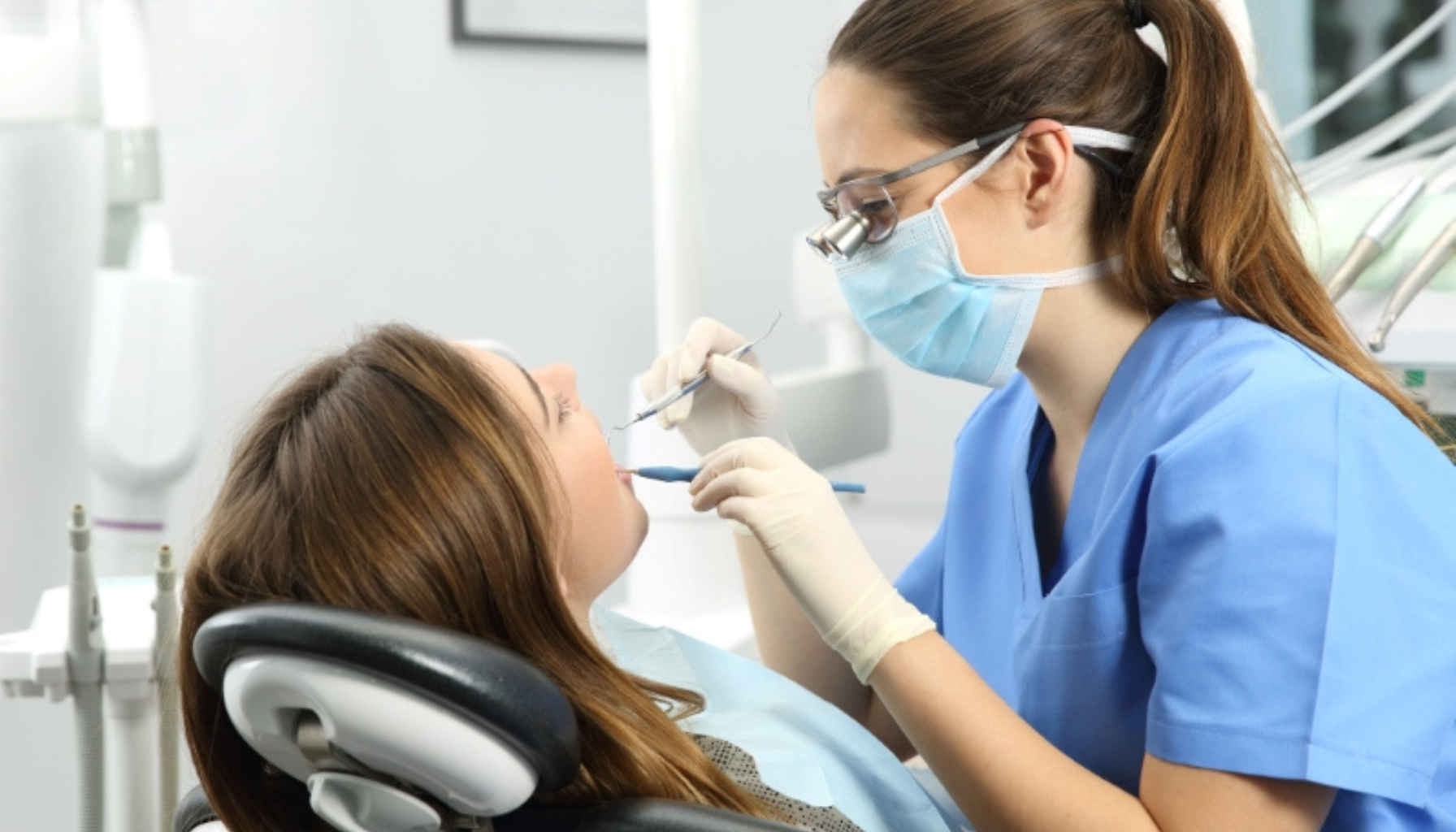 Tannlege undersøker kvinnes tenner med speil og instrumenter under en tannbehandling på klinikk.