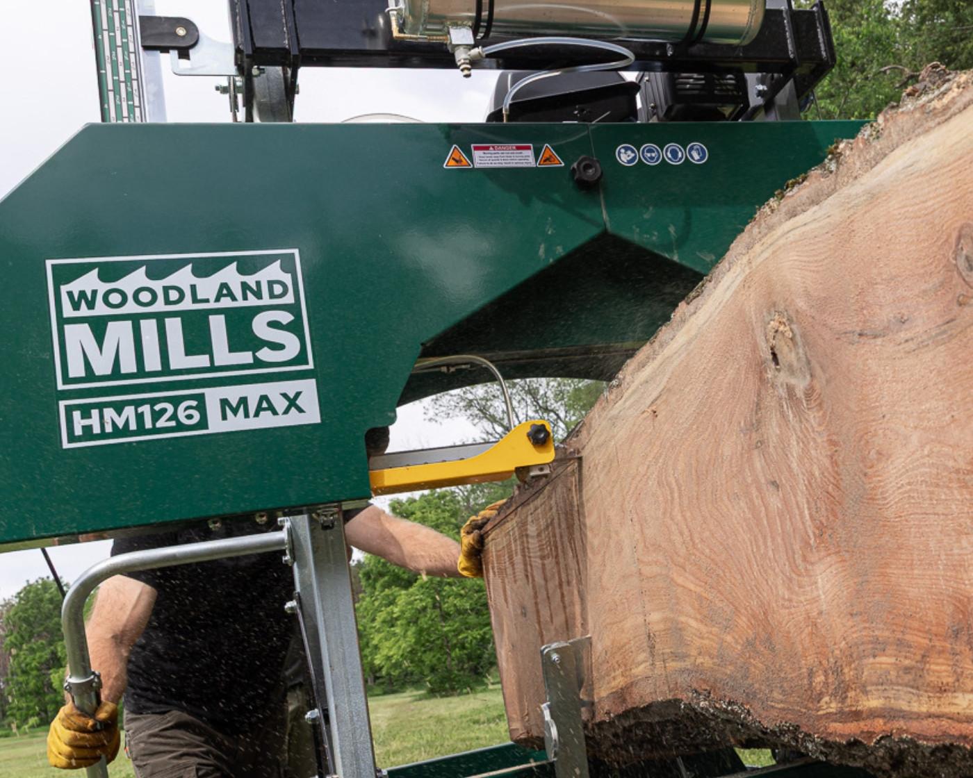 The Woodland Mills HM126MAX Portable Sawmill cutting into a log.