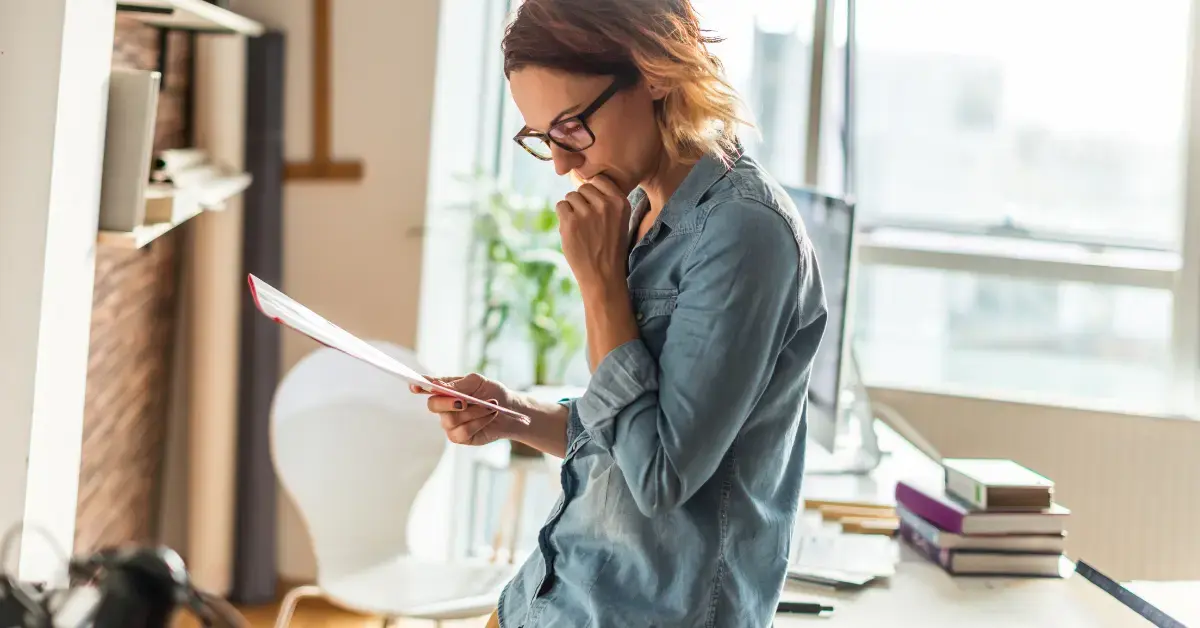 Woman reviewing tax forms and creator income records for possible IRS red flags.